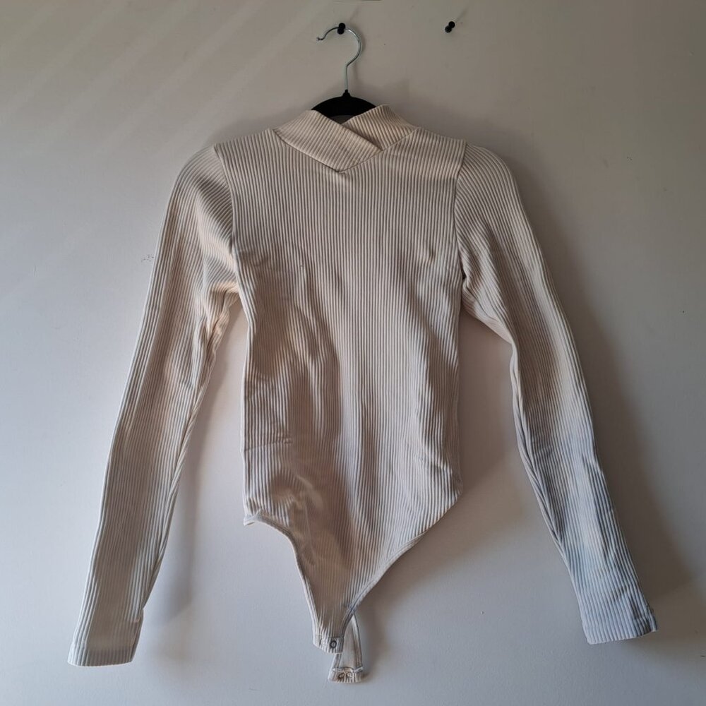 Stretchy, white and long sleeve bodysuit from Aura.